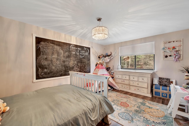 bedroom with hardwood / wood-style floors and a notable chandelier