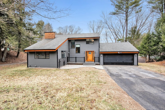 raised ranch featuring a front lawn and a garage