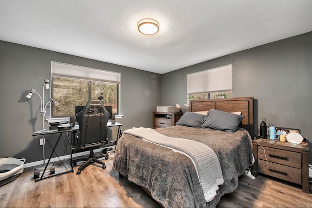 bedroom featuring a textured ceiling and light wood-type flooring