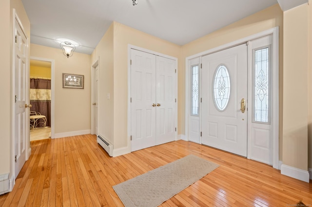 entryway with light wood-type flooring and a baseboard radiator