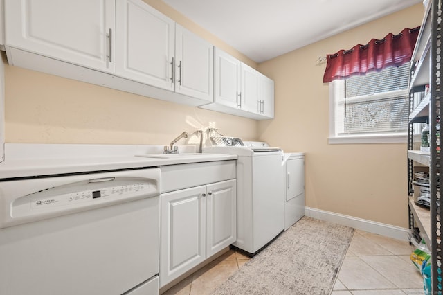 laundry area featuring sink, light tile patterned floors, cabinets, and independent washer and dryer