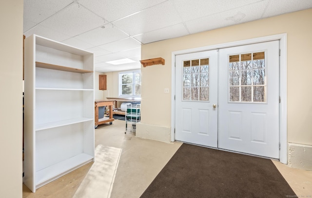 doorway to outside with a drop ceiling