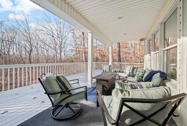 wooden terrace with an outdoor living space