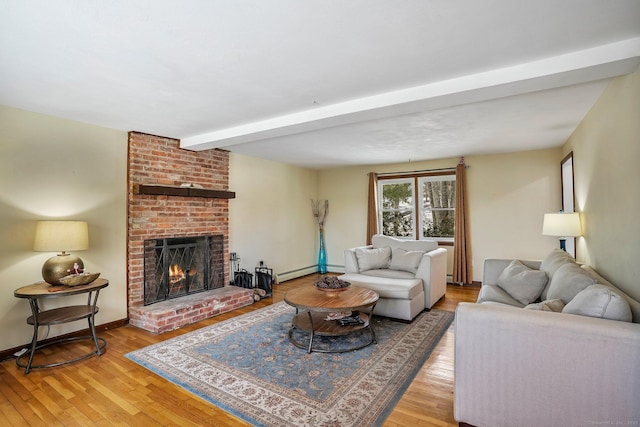 living room featuring a brick fireplace, light hardwood / wood-style flooring, beamed ceiling, and baseboard heating