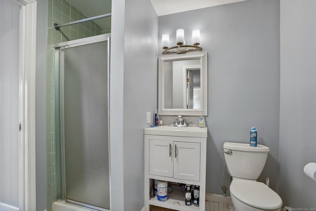 bathroom with toilet, a shower with shower door, and vanity