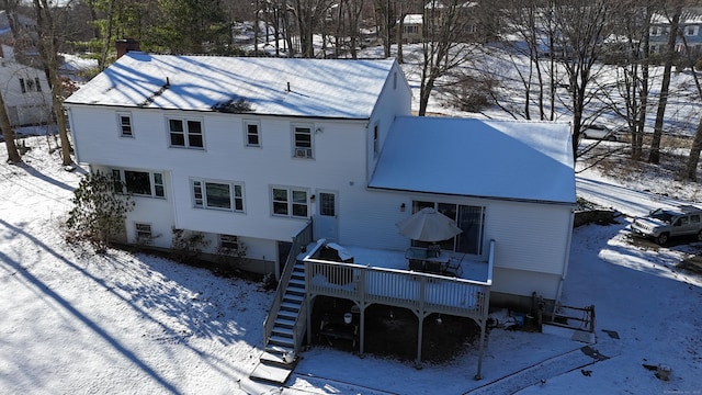 snow covered rear of property featuring a deck