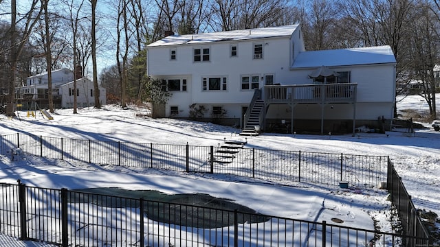 snow covered house featuring a wooden deck