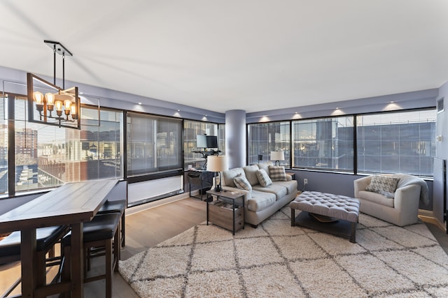 living room with hardwood / wood-style flooring, an inviting chandelier, and a healthy amount of sunlight