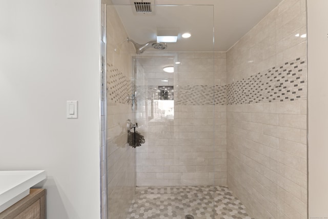 bathroom featuring a tile shower and vanity