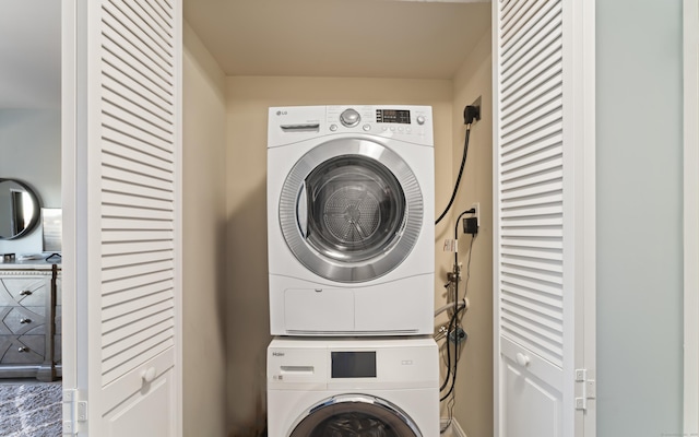 clothes washing area featuring stacked washer / dryer