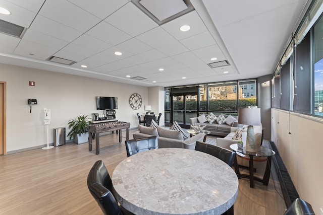 dining space featuring plenty of natural light, light hardwood / wood-style floors, and a wall of windows