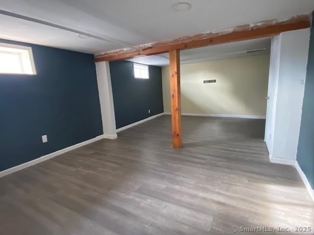 basement with dark hardwood / wood-style floors