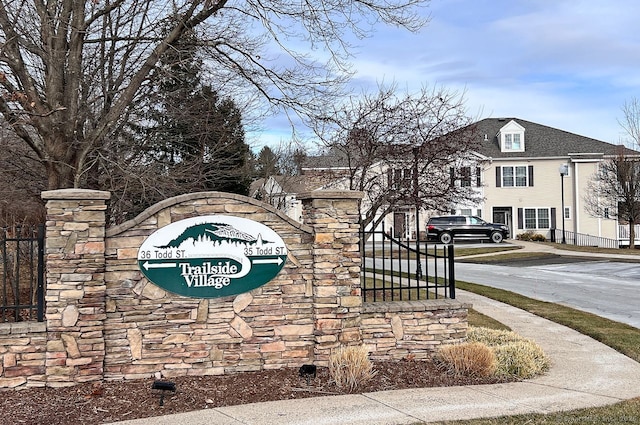 community / neighborhood sign featuring a gate and driveway