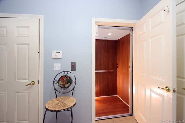 entryway with elevator and light tile patterned floors