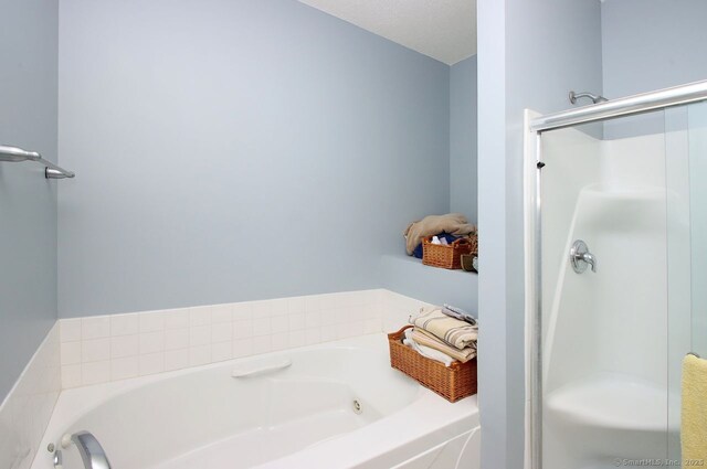 bathroom featuring shower with separate bathtub