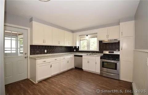 kitchen with sink, white cabinets, dark wood-type flooring, and appliances with stainless steel finishes