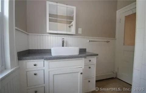 bathroom featuring a baseboard heating unit and sink