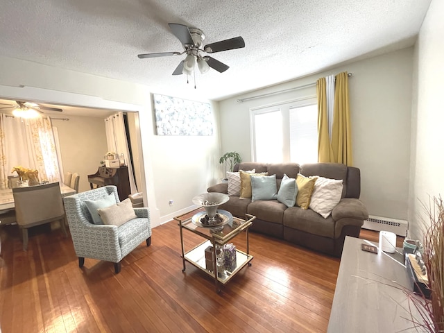 living room with ceiling fan, a baseboard radiator, a textured ceiling, and hardwood / wood-style flooring