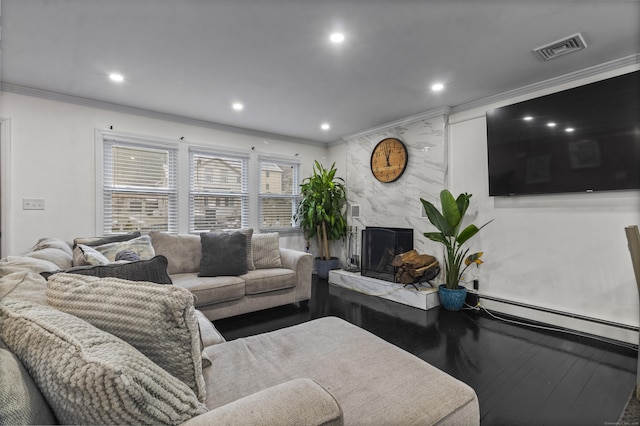 living room featuring baseboard heating, a high end fireplace, wood-type flooring, and ornamental molding