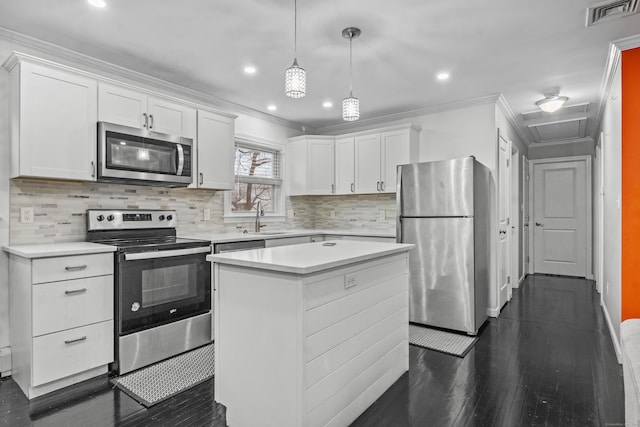 kitchen with white cabinetry, a center island, hanging light fixtures, and appliances with stainless steel finishes