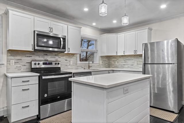 kitchen with pendant lighting, sink, a kitchen island, white cabinetry, and stainless steel appliances