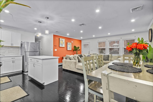 kitchen with pendant lighting, white cabinets, stainless steel fridge, ornamental molding, and dark hardwood / wood-style flooring