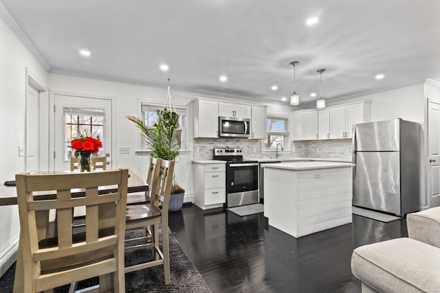 kitchen featuring pendant lighting, sink, white cabinetry, and stainless steel appliances