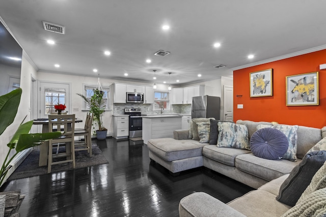 living room with dark hardwood / wood-style flooring and crown molding