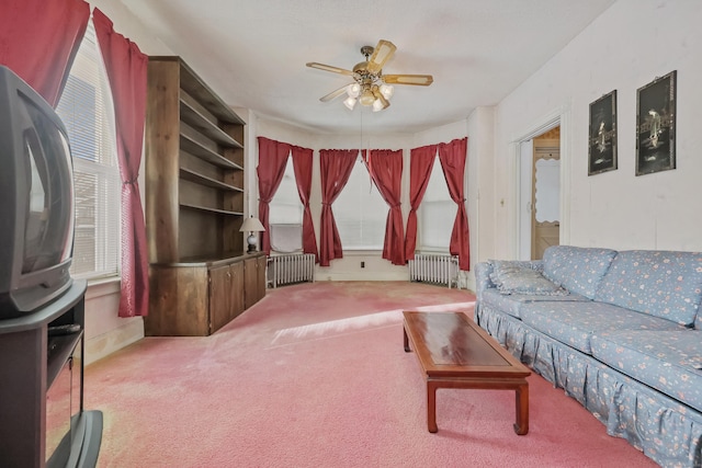 carpeted living room featuring ceiling fan and radiator