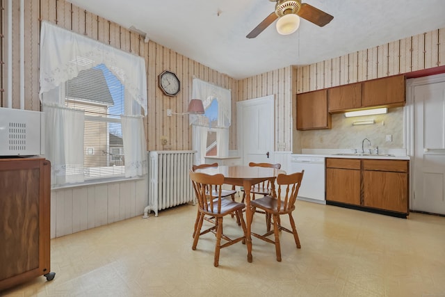 dining space with ceiling fan, sink, and radiator