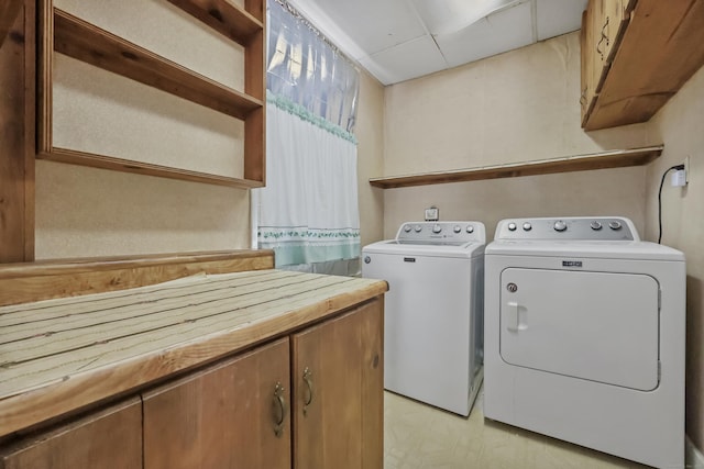 washroom featuring washing machine and dryer and cabinets