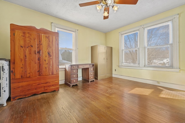 bedroom with light hardwood / wood-style floors, a textured ceiling, and ceiling fan