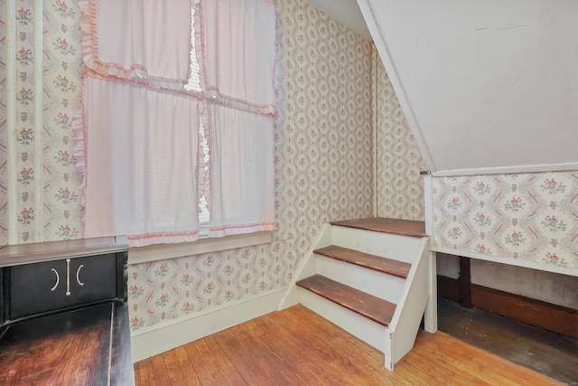 staircase with hardwood / wood-style flooring and vaulted ceiling