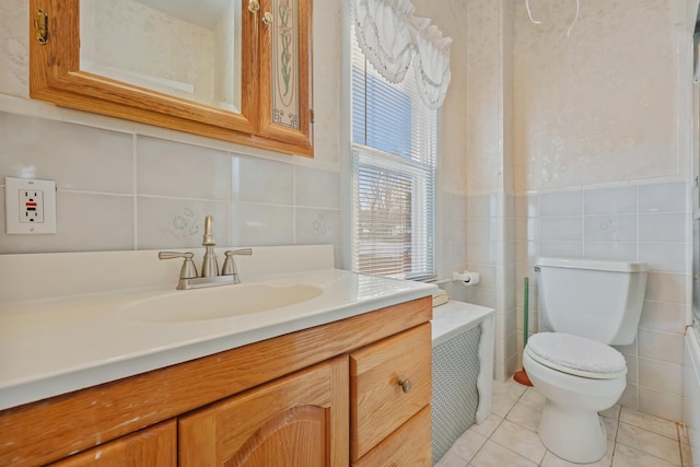 bathroom with tile walls, tile patterned floors, vanity, and toilet