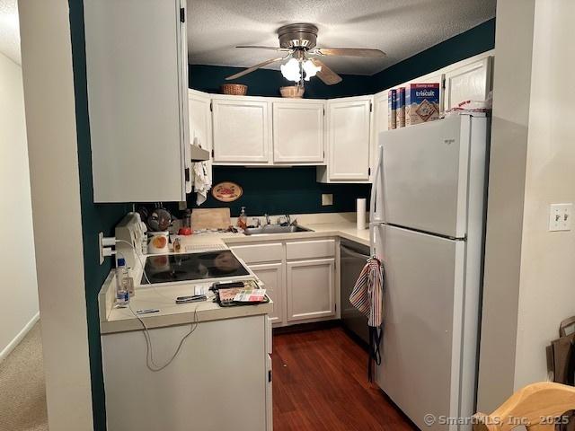 kitchen featuring white cabinets, white refrigerator, sink, dark hardwood / wood-style floors, and ceiling fan