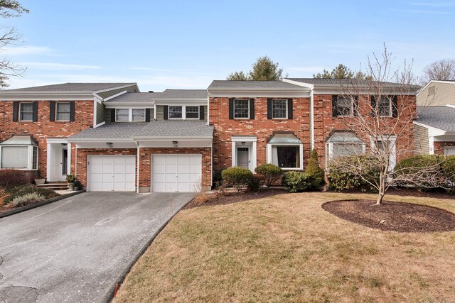 multi unit property featuring a front yard and a garage