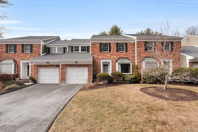 multi unit property with a garage and a front yard