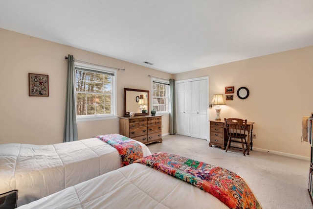 bedroom with baseboards, light carpet, a closet, and visible vents