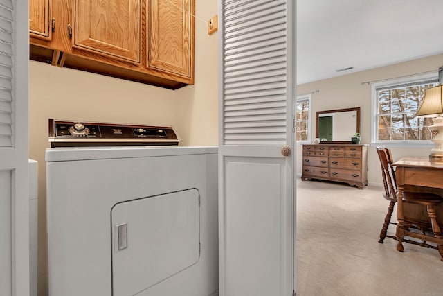 clothes washing area featuring cabinet space, visible vents, washer / dryer, and light carpet