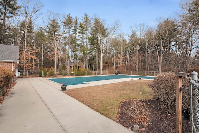 community pool featuring a lawn and fence