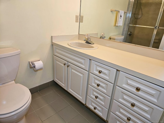 full bathroom with vanity, baseboards, tile patterned floors, toilet, and a shower with door