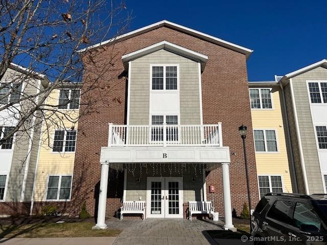 view of front of home with a balcony and french doors