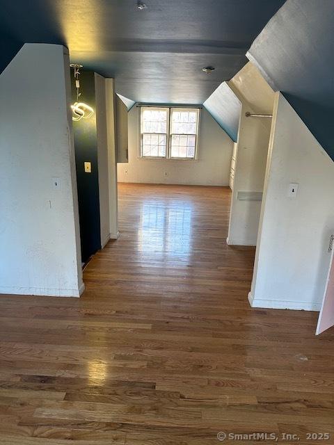 bonus room featuring lofted ceiling and dark wood-type flooring