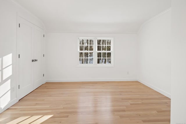 spare room with light wood-type flooring and ornamental molding