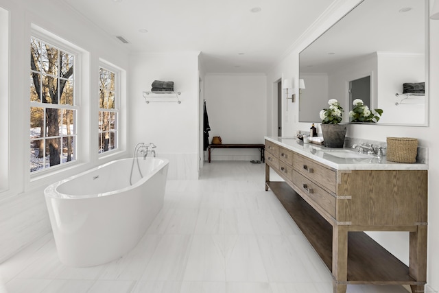 bathroom featuring ornamental molding, vanity, and a tub