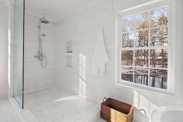 bathroom with ornamental molding, tiled shower, and tile walls