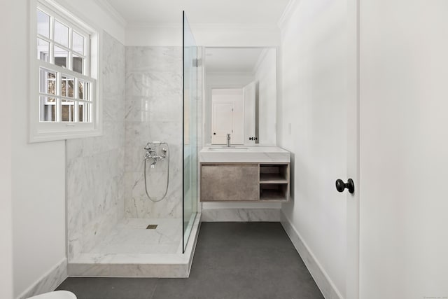 bathroom featuring a tile shower, vanity, and ornamental molding