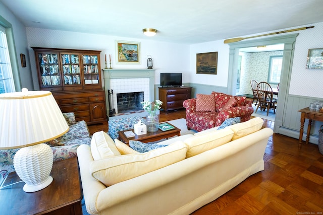 living room featuring dark parquet flooring, a tile fireplace, and a baseboard radiator