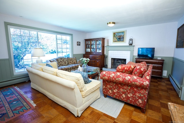 living room featuring dark parquet flooring, a fireplace, and a baseboard heating unit