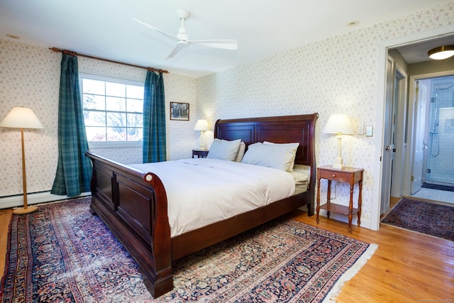 bedroom featuring ceiling fan, baseboard heating, connected bathroom, and light hardwood / wood-style flooring